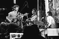 a black and white photo of a group of people playing music