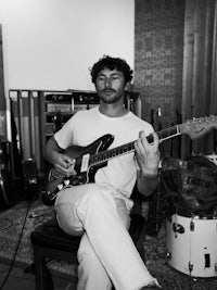 a man playing an electric guitar in a recording studio