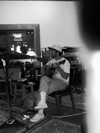 a man sitting in a chair playing an acoustic guitar