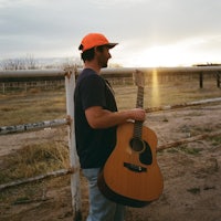 a man holding an acoustic guitar