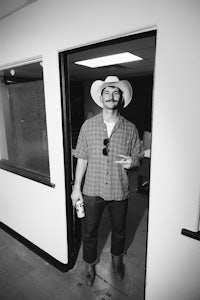 a man in a cowboy hat standing in a doorway