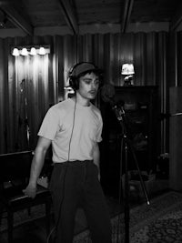 a man standing in front of a microphone in a recording studio