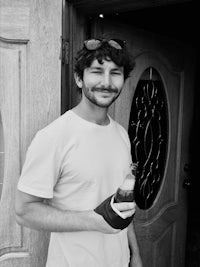 a black and white photo of a man holding a bottle of coca cola