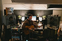 two men playing guitar in a recording studio