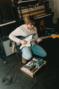 a man playing a guitar in a room