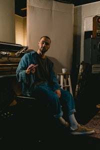 a man sitting on a chair in a recording studio