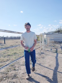 a man standing in front of a fence