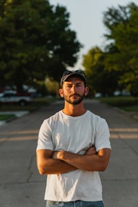 a man standing in a street with his arms crossed