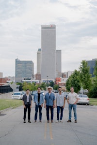 a group of men standing in front of a city