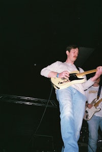 a man playing a guitar on stage